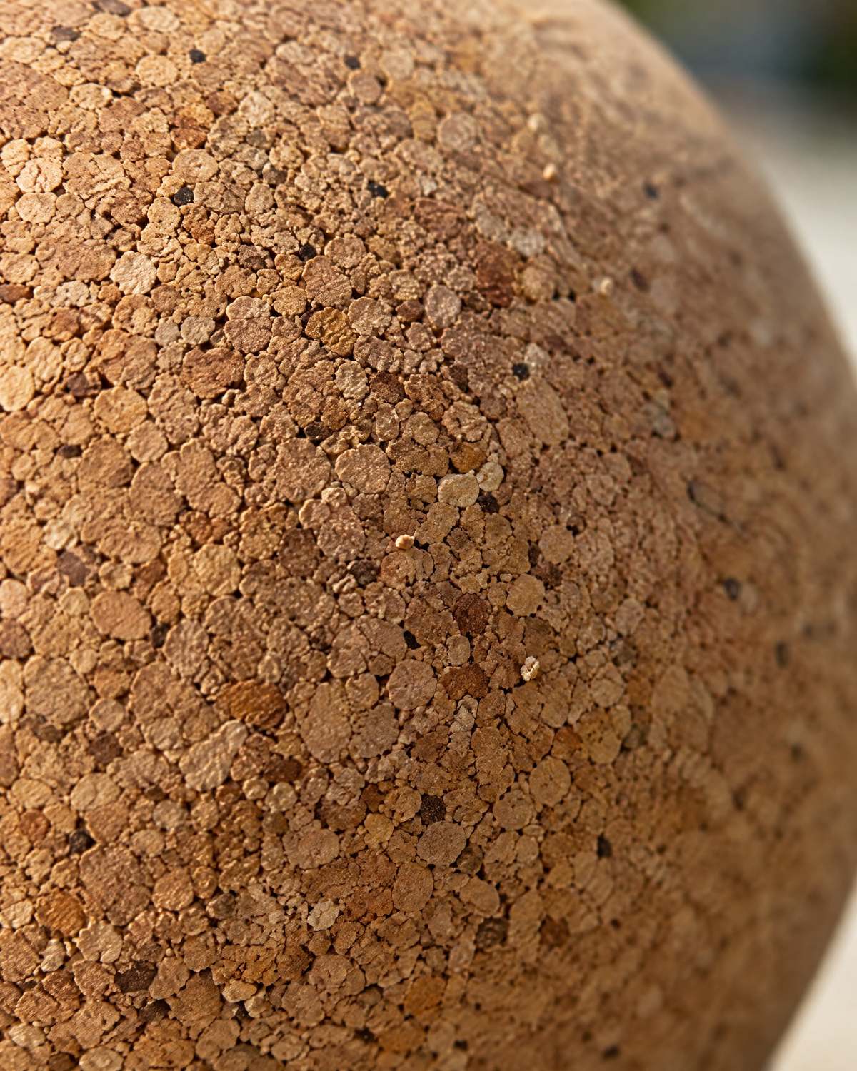 Extreme close-up of the ball's surface, showing tightly packed natural cork granules.